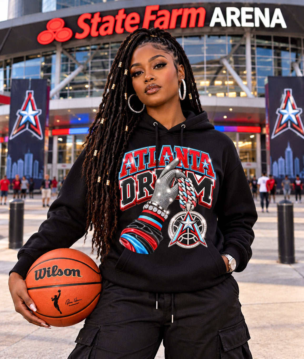 Black Atlanta Dream graphic hoodie modeled by a woman holding a basketball outside State Farm Arena
