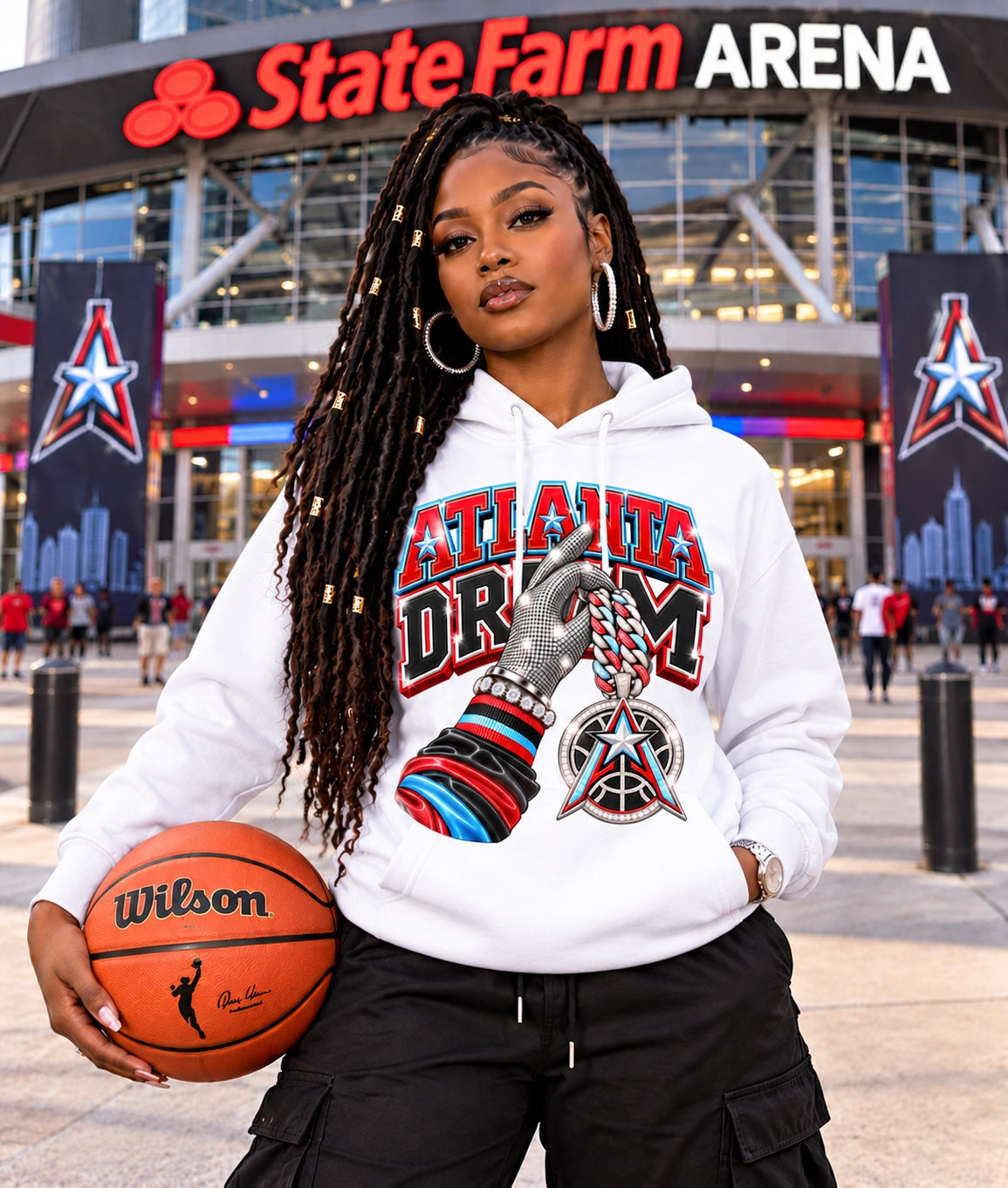 White Atlanta Dream graphic hoodie modeled by a woman holding a basketball outside State Farm Arena