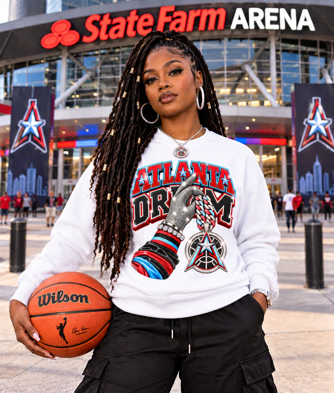 White Atlanta Dream graphic sweatshirt modeled by a woman holding a basketball outside State Farm Arena